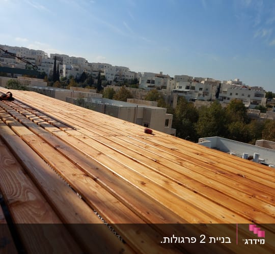 משטח עץ בנוי על גג עם שמיים כחולים